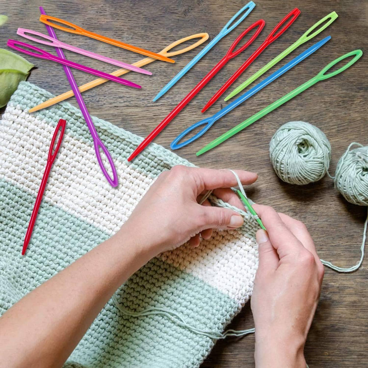 Plastic lacing needles in bright colors, hand stitching on knitted fabric with yarn