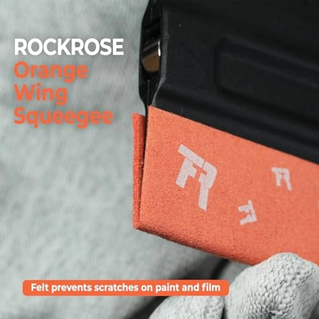 Close-up of orange felt edge and black squeegee blade against a glove surface.