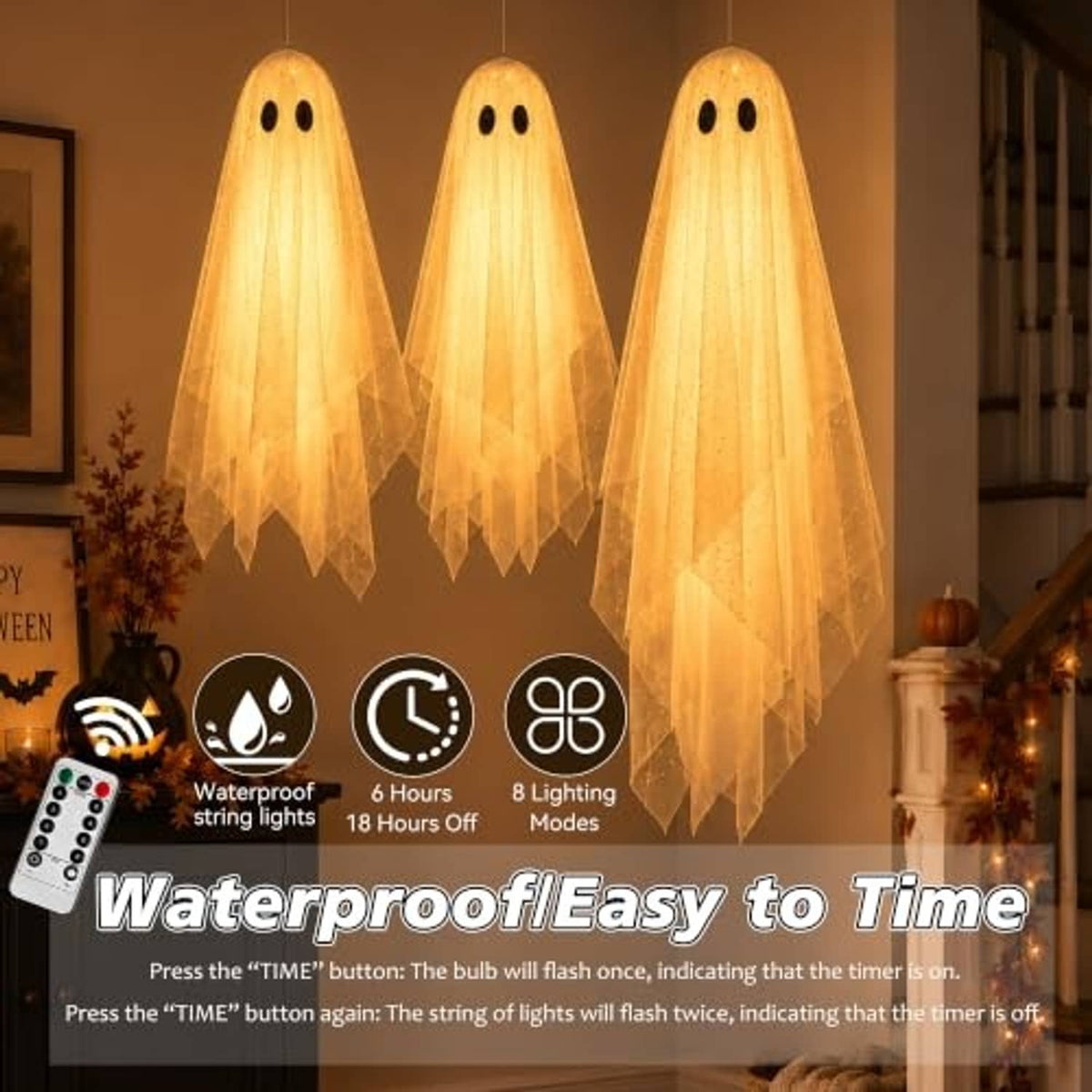 Three warm-lit hanging ghost decorations with black eyes and sheer fabric tails for indoor use