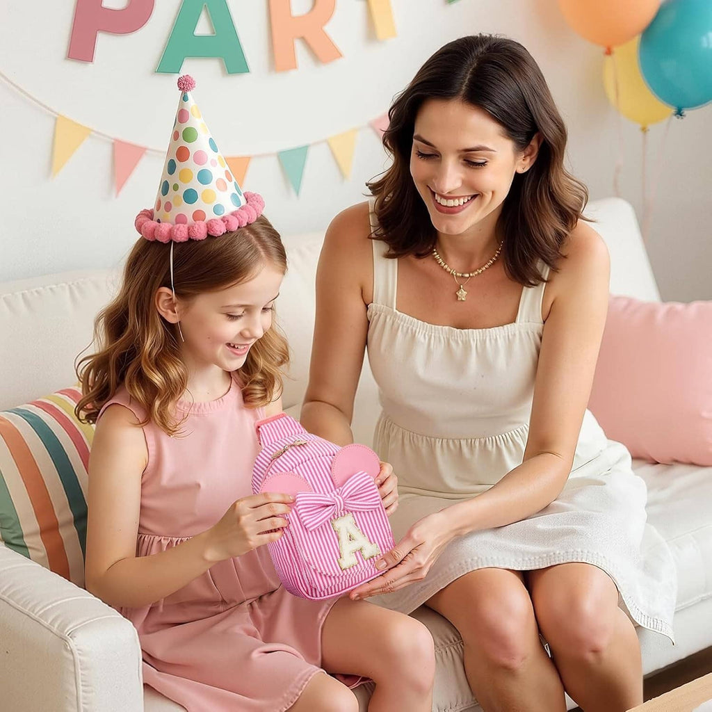 Kids holding pink striped sling bags with bows and letter A patches