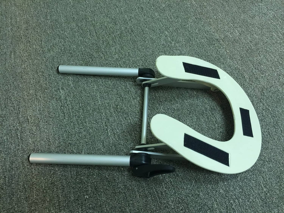Adjustable face support with pale plate and black straps on two silver metal bars