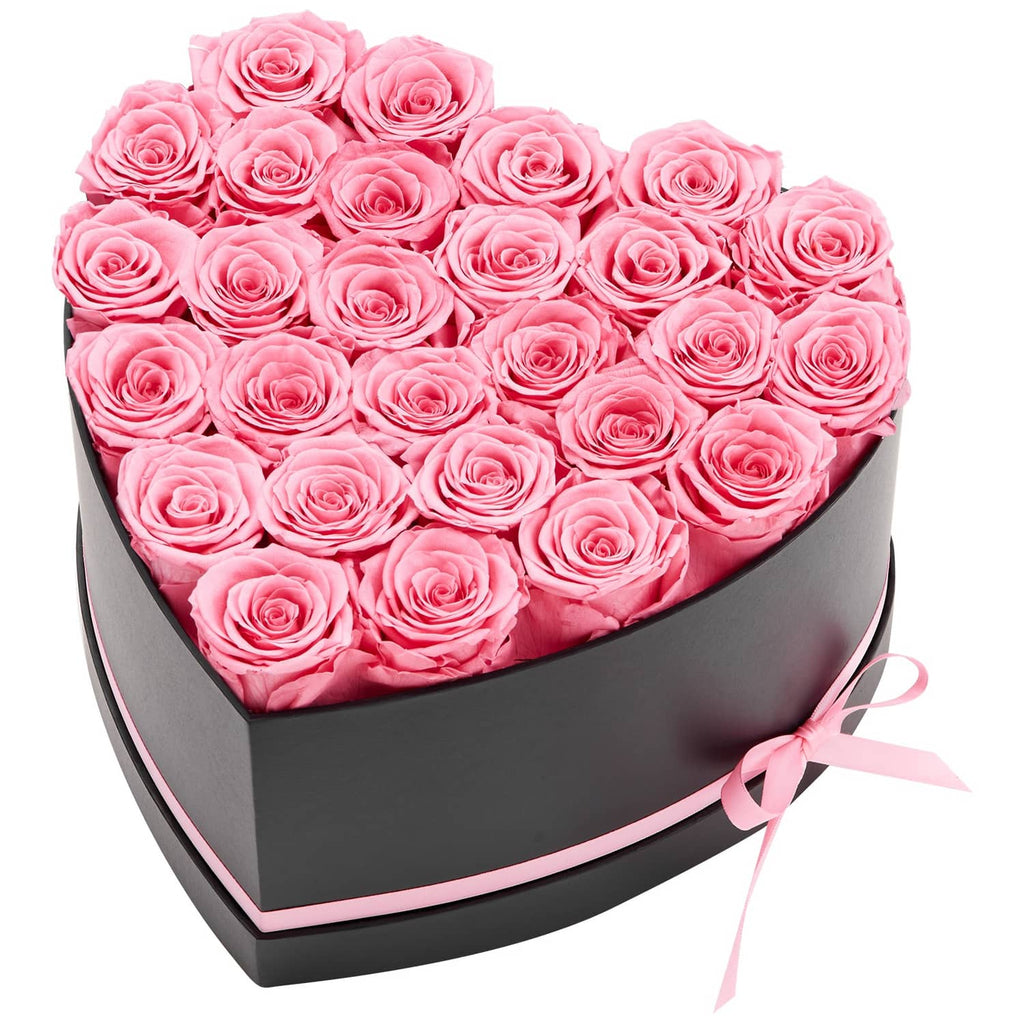 Heart-shaped box of pink preserved roses with ribbon bow on the side
