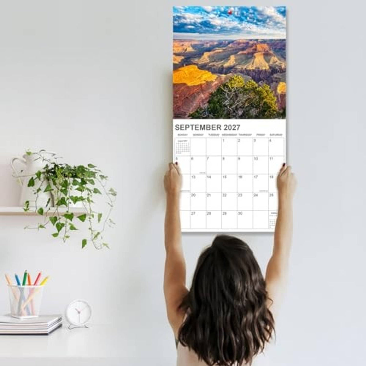 National Parks wall calendar held up, showing September 2027 page with scenic photo.