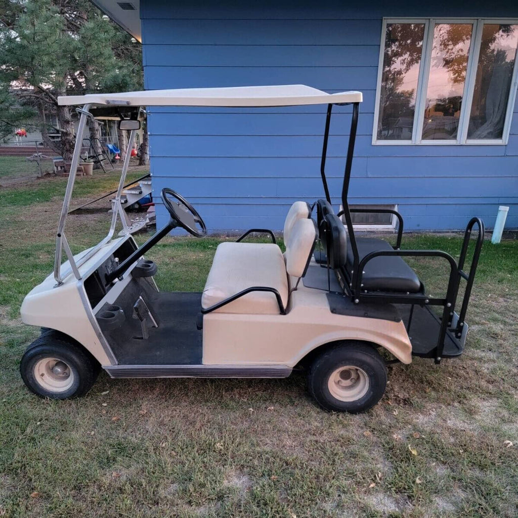 Golf cart with installed rear flip seat kit featuring black armrests and platform