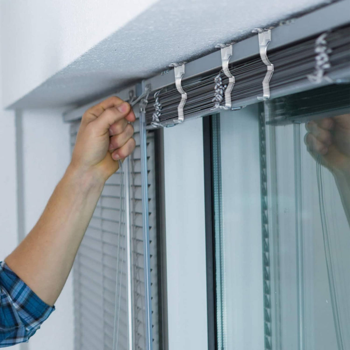 Clear valance clips mounted along the top of window blinds for valance hold
