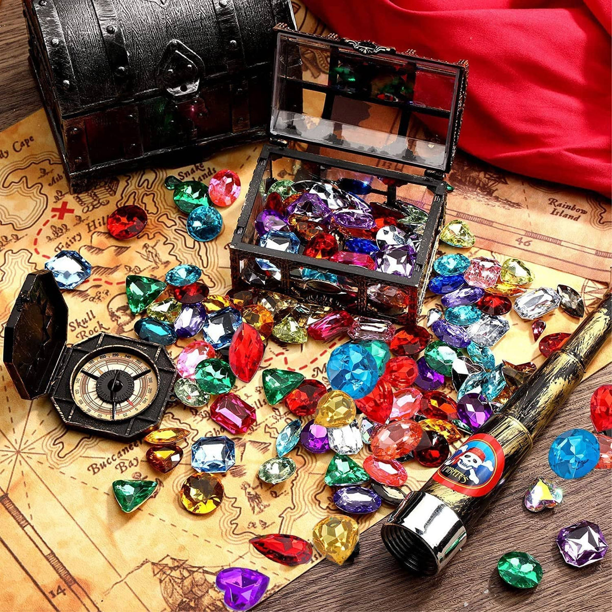 Open chest of multi-colored faceted jewel stones with mixed gem shapes and sizes