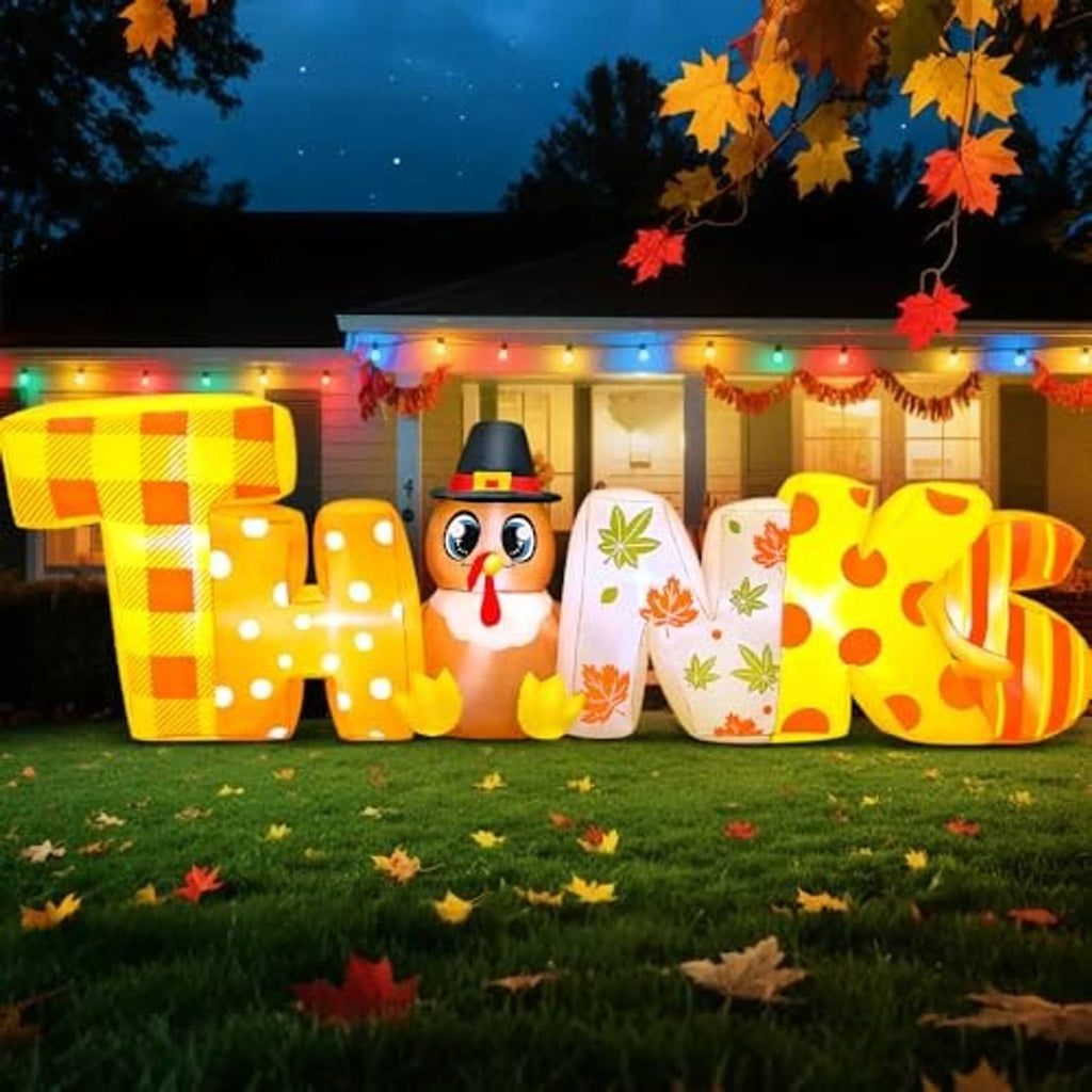 Nighttime Thanksgiving inflatable “THANKS” letters with turkey face, warm yellow and orange glow
