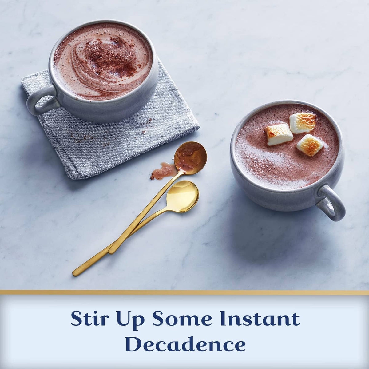 Two mugs of hot cocoa with marshmallows and chocolate cookie pieces