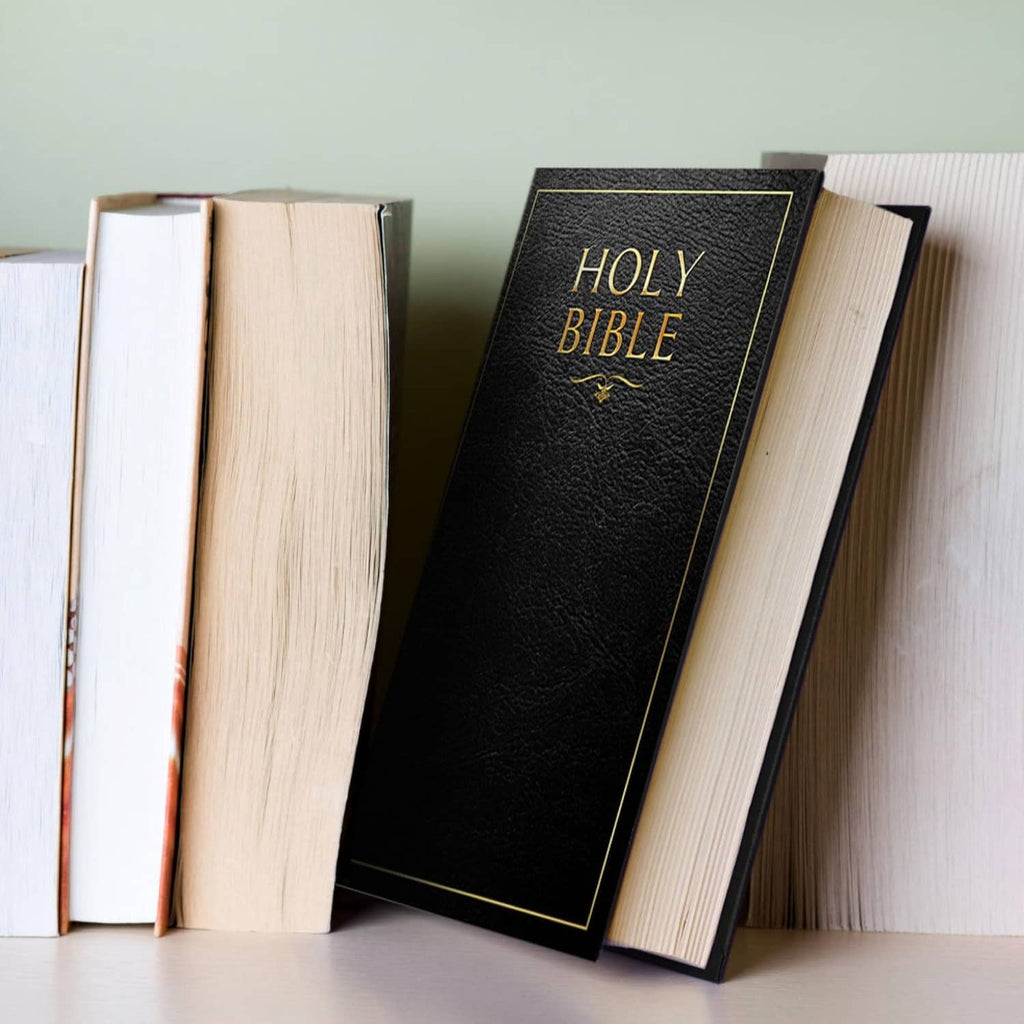 Black faux Bible book safe with gold trim, standing on books