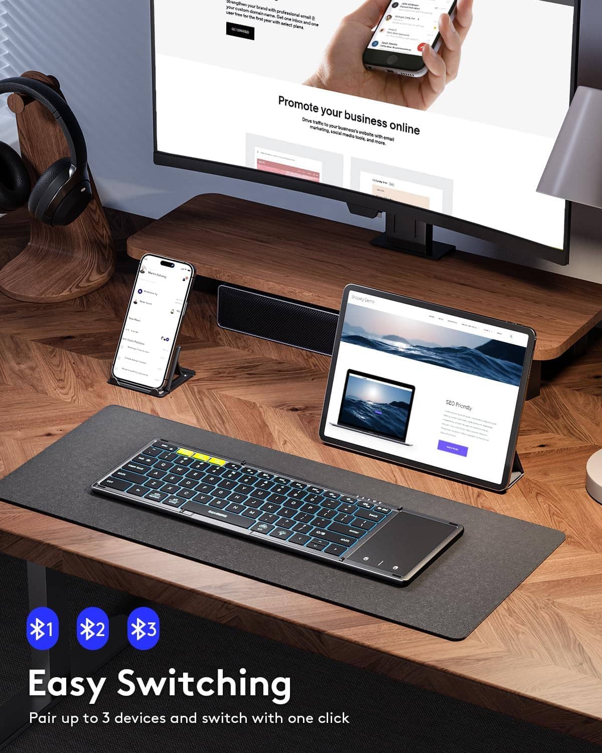 Foldable wireless keyboard with touchpad and blue backlit keys on a desk