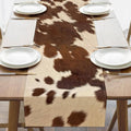 Cow print table runner with brown and white patches and straight stitched edges