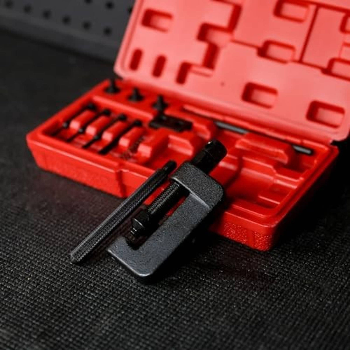 Chain breaker tool kit tool head with threaded rod, seated in red storage case