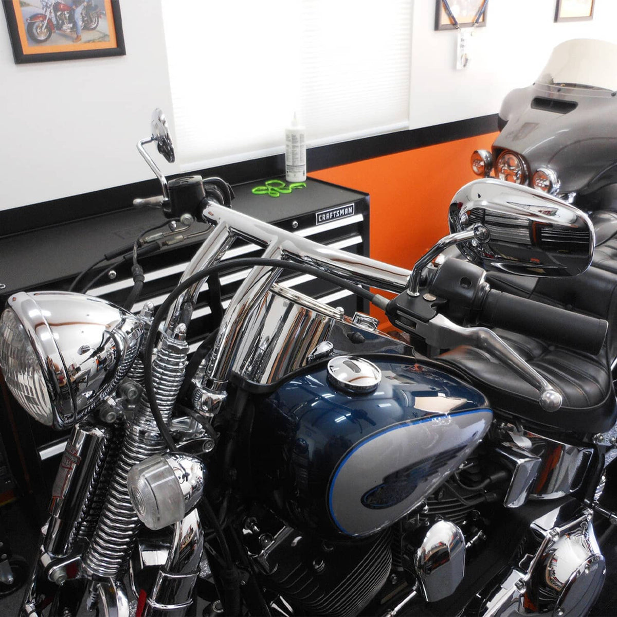 Chrome motorcycle handlebars with T-bar risers, black grips, and front controls