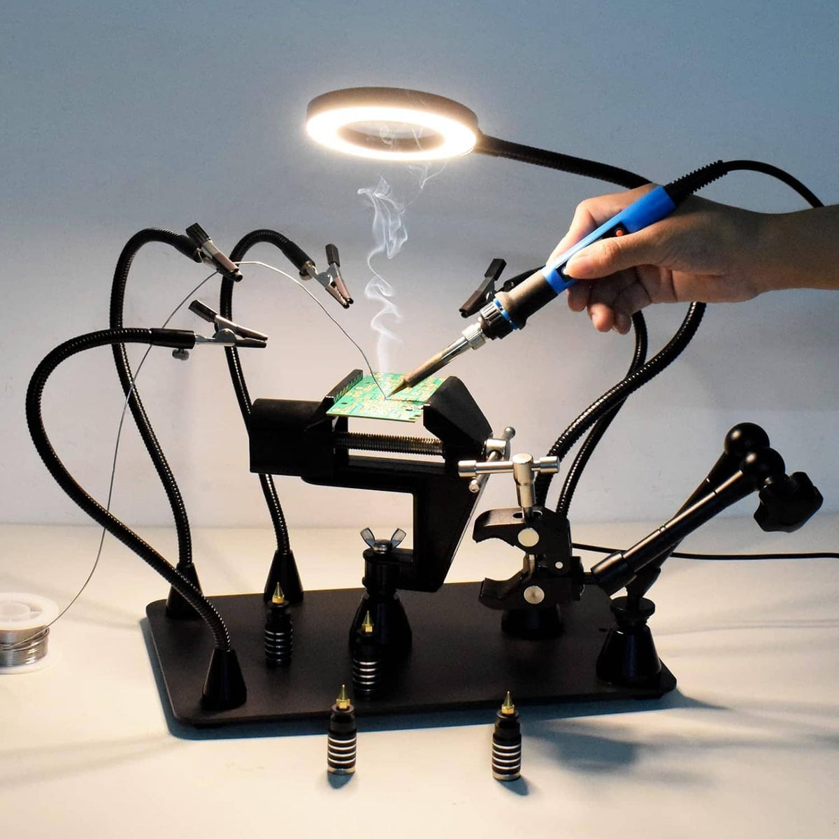 Magnetic soldering third hand PCB holder with LED magnifier while a hand solders a circuit