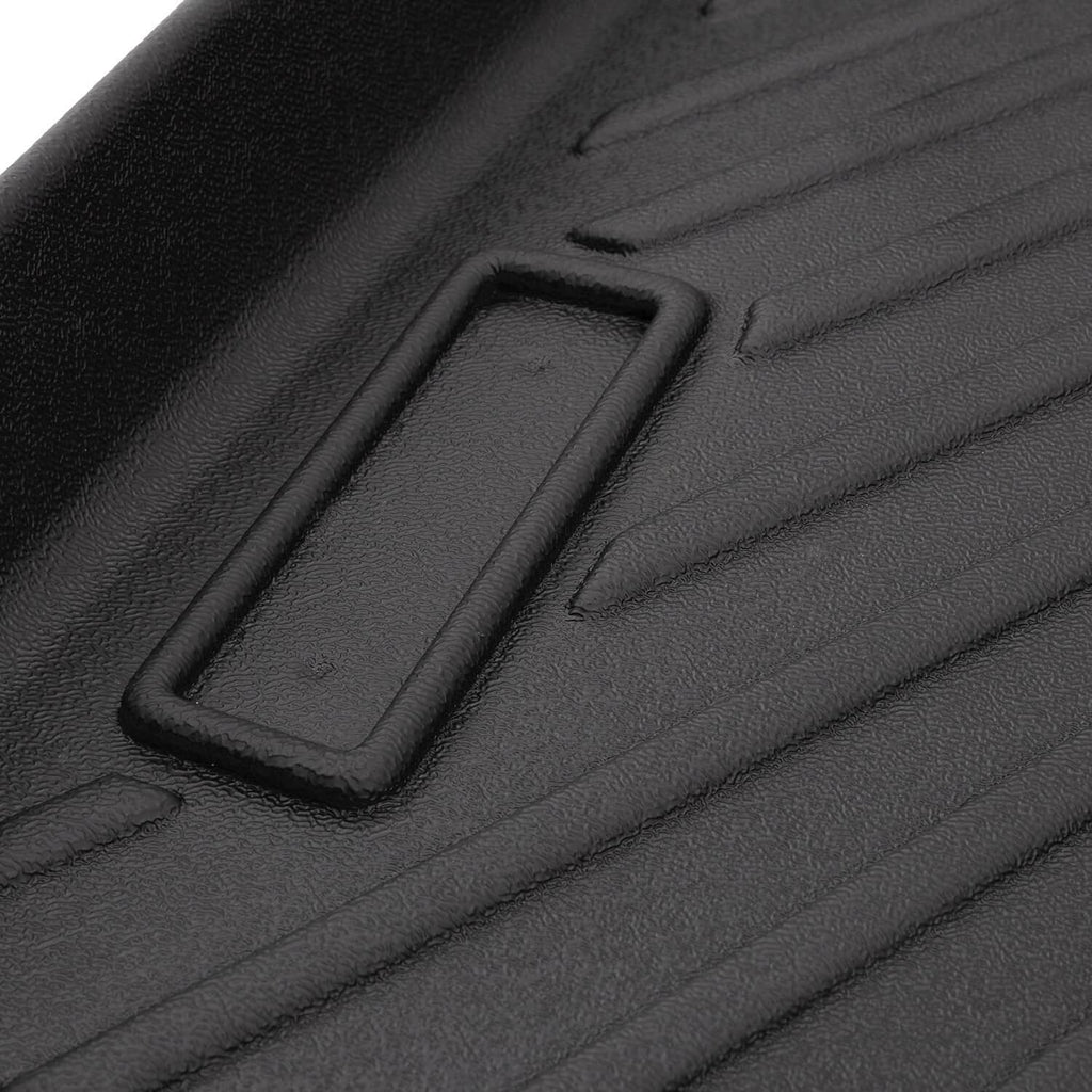 Close-up of black floor mat retention slot bordered by raised rubber frame