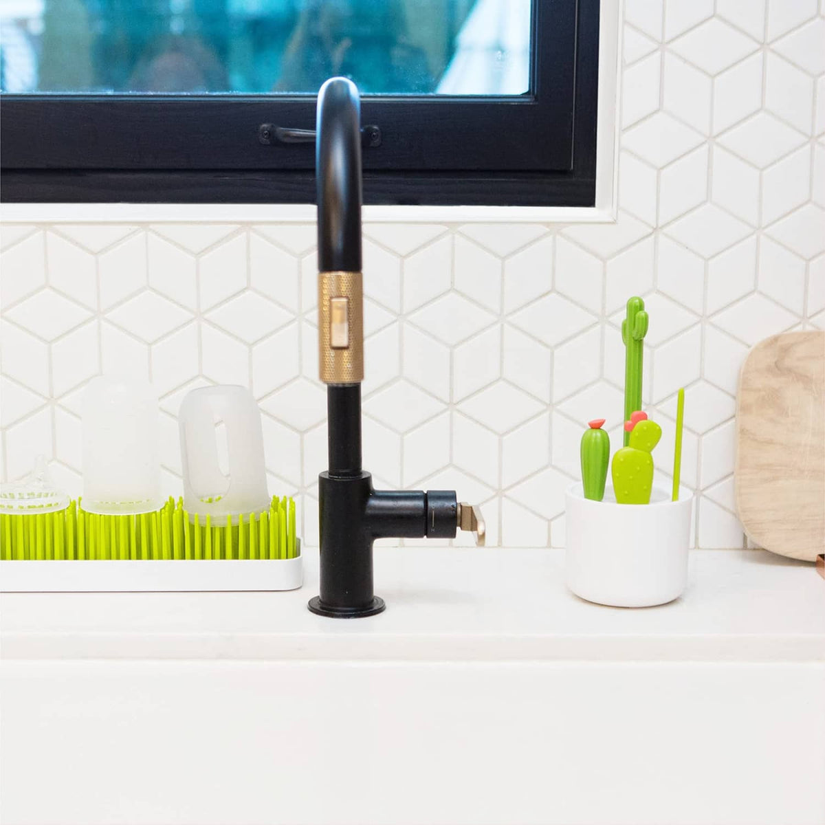 Green cactus brush set in white cup on kitchen countertop
