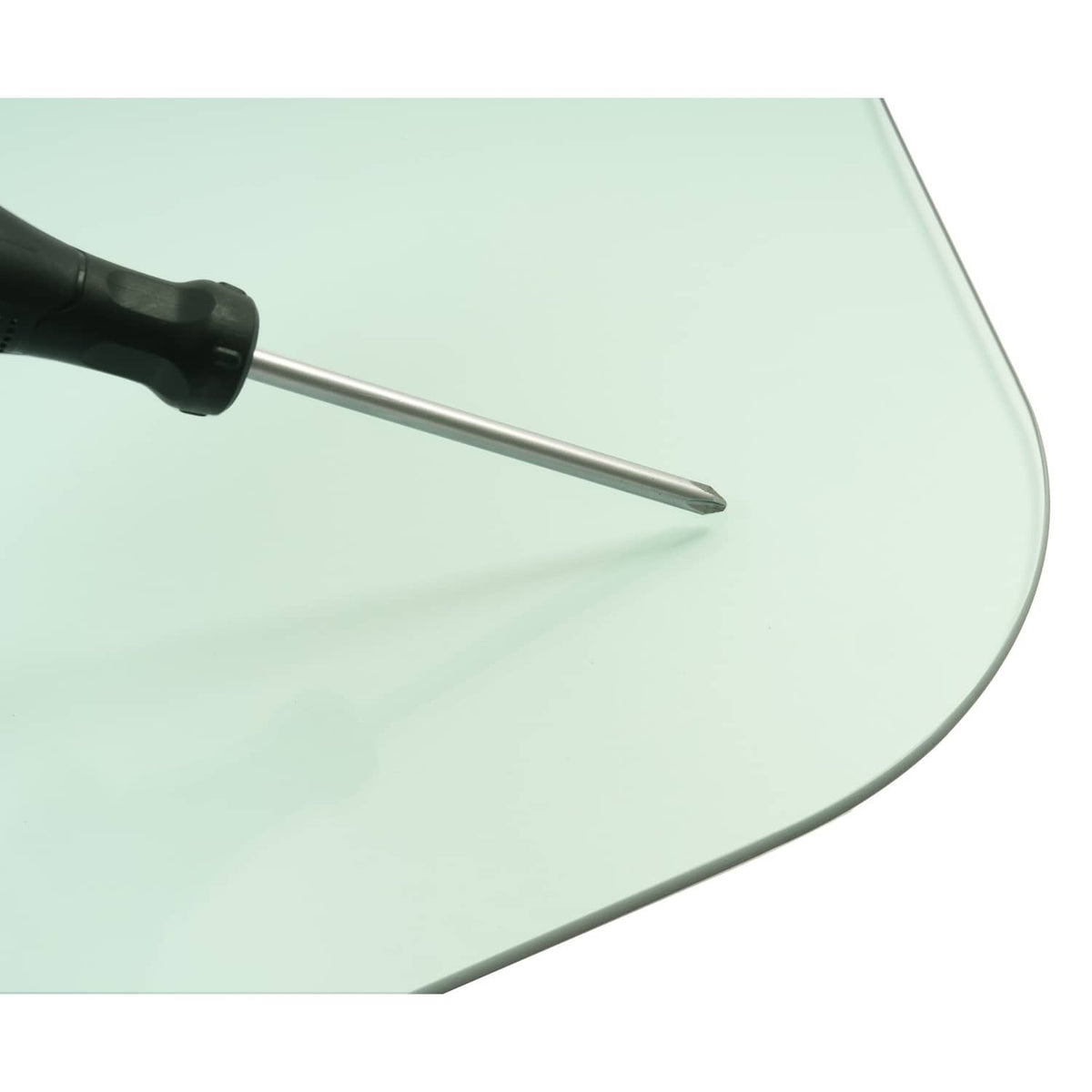 Tinted side glass window panel edge with screwdriver tip near the curved frame