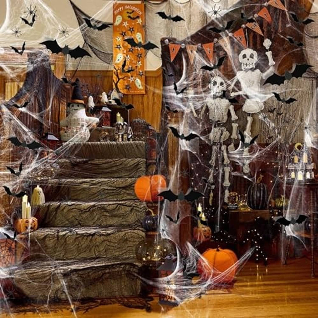 Halloween spider web decoration with black bats, faux spiders, and hanging skull ornaments