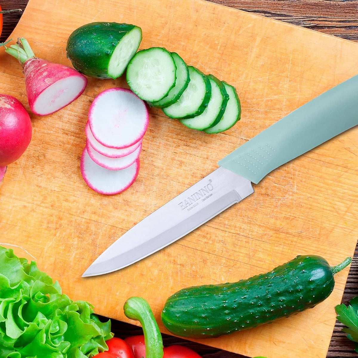 Silver paring knife on wood cutting board next to sliced vegetables
