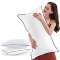 King-size white bed pillows with blue piping, shown upright and stacked