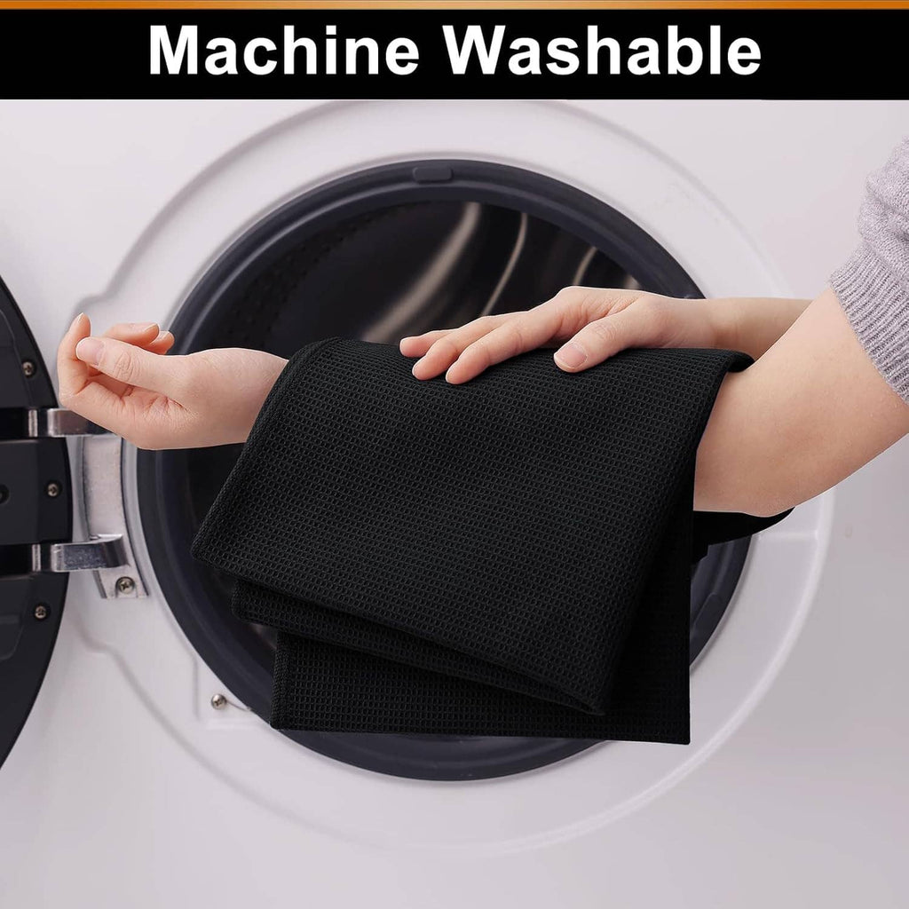 Black waffle weave cotton towel inside a washing machine drum