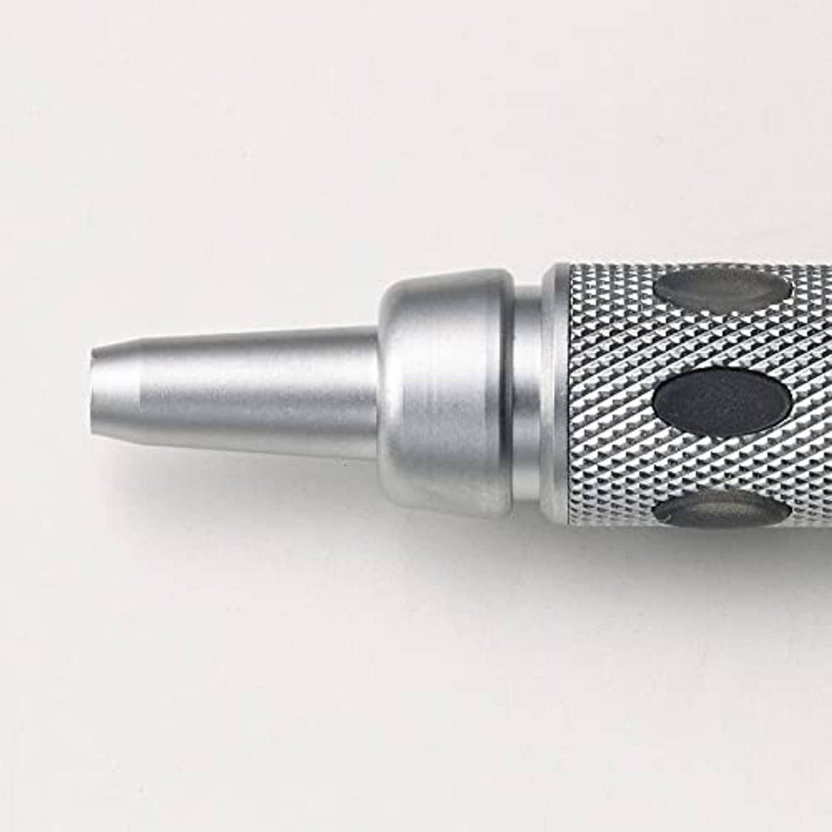 Close-up of silver pencil tip and textured grip with rounded spot pattern