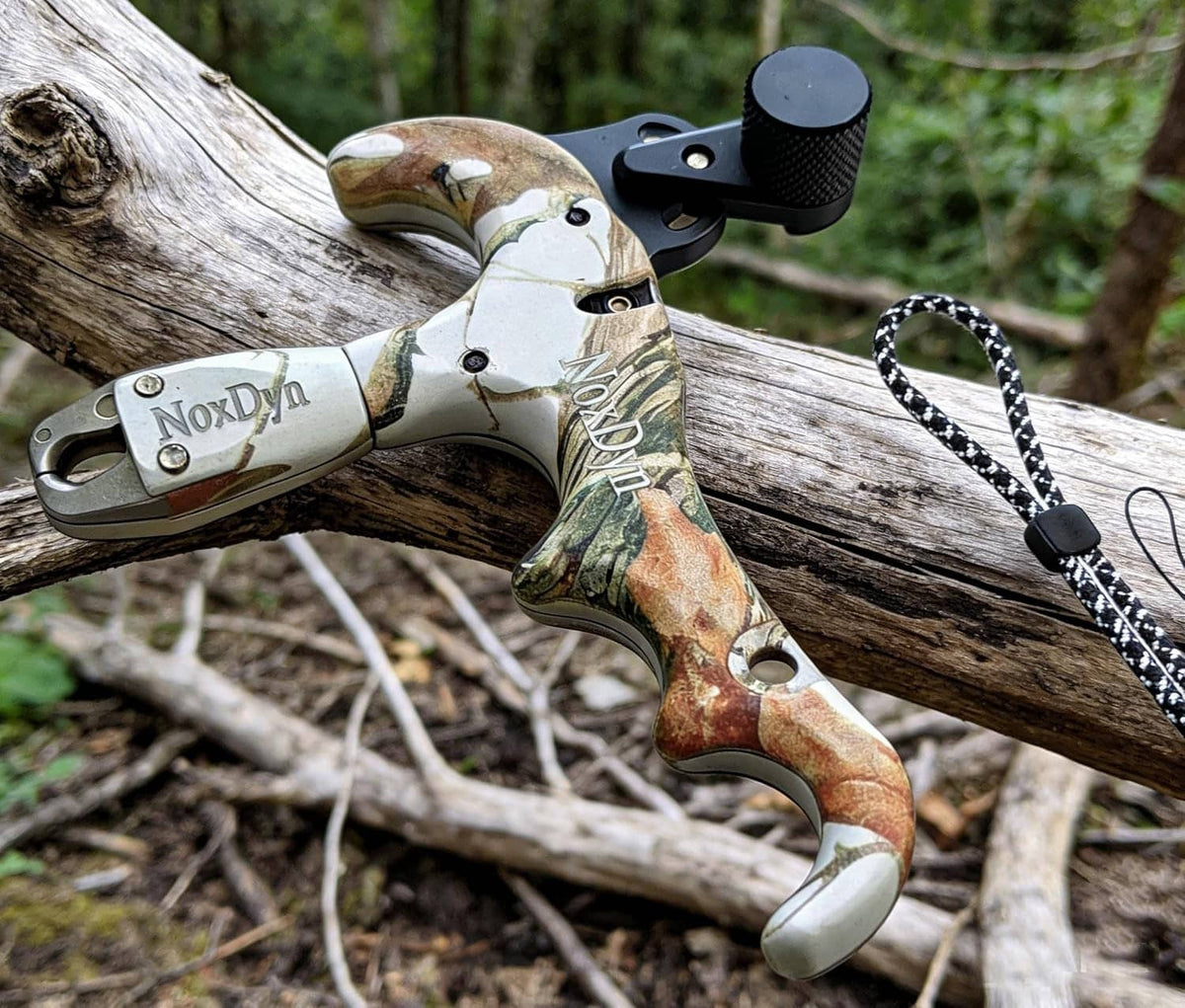 Archery bow thumb release with white-and-green camo handle, black trigger, rope lanyard