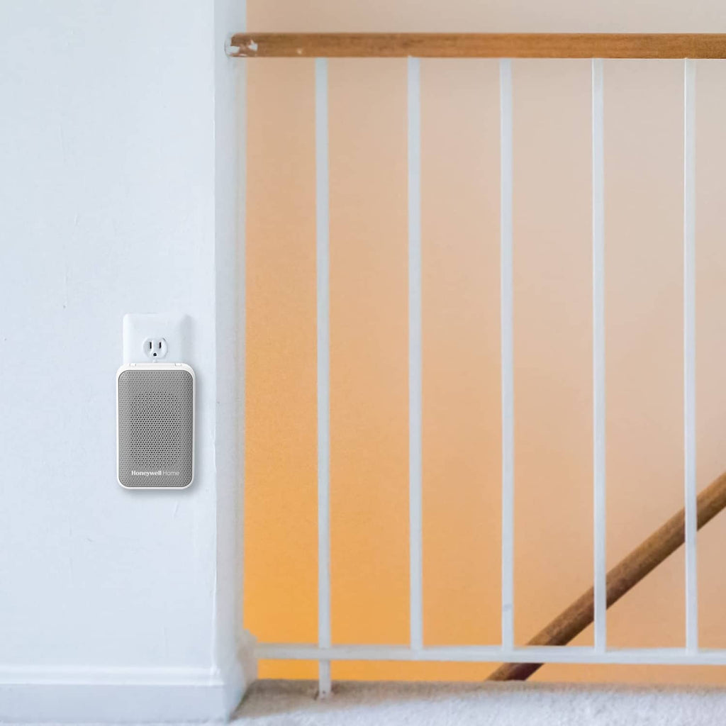 Small white wireless doorbell button mounted on wall near door railing