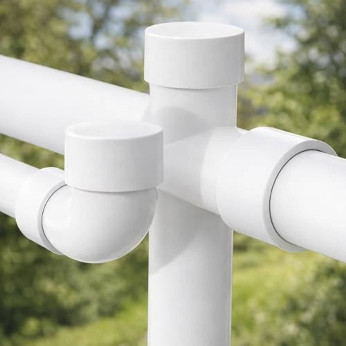 White PVC pipe end caps on a cross joint, round protective end covers