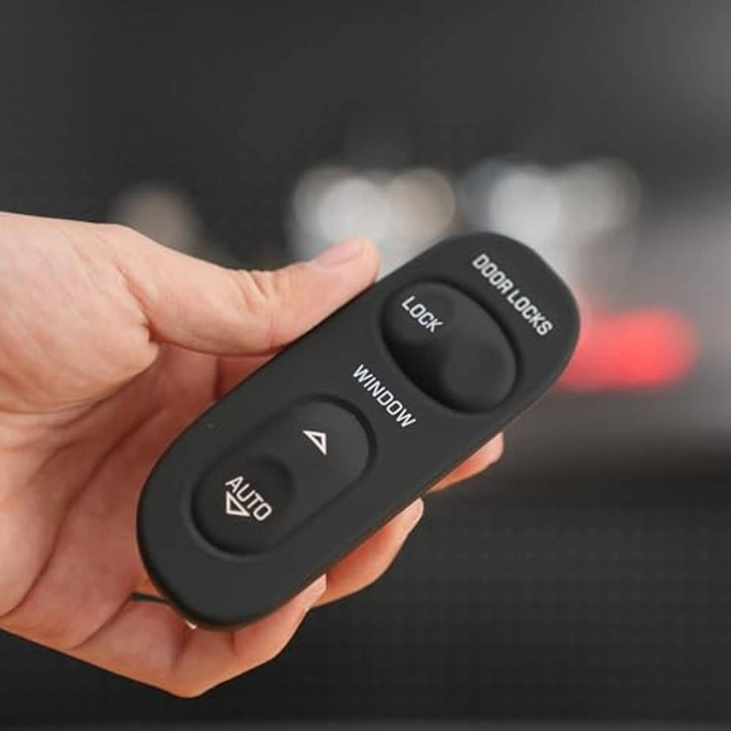 Master power window switch held in hand showing door lock, window, and AUTO buttons