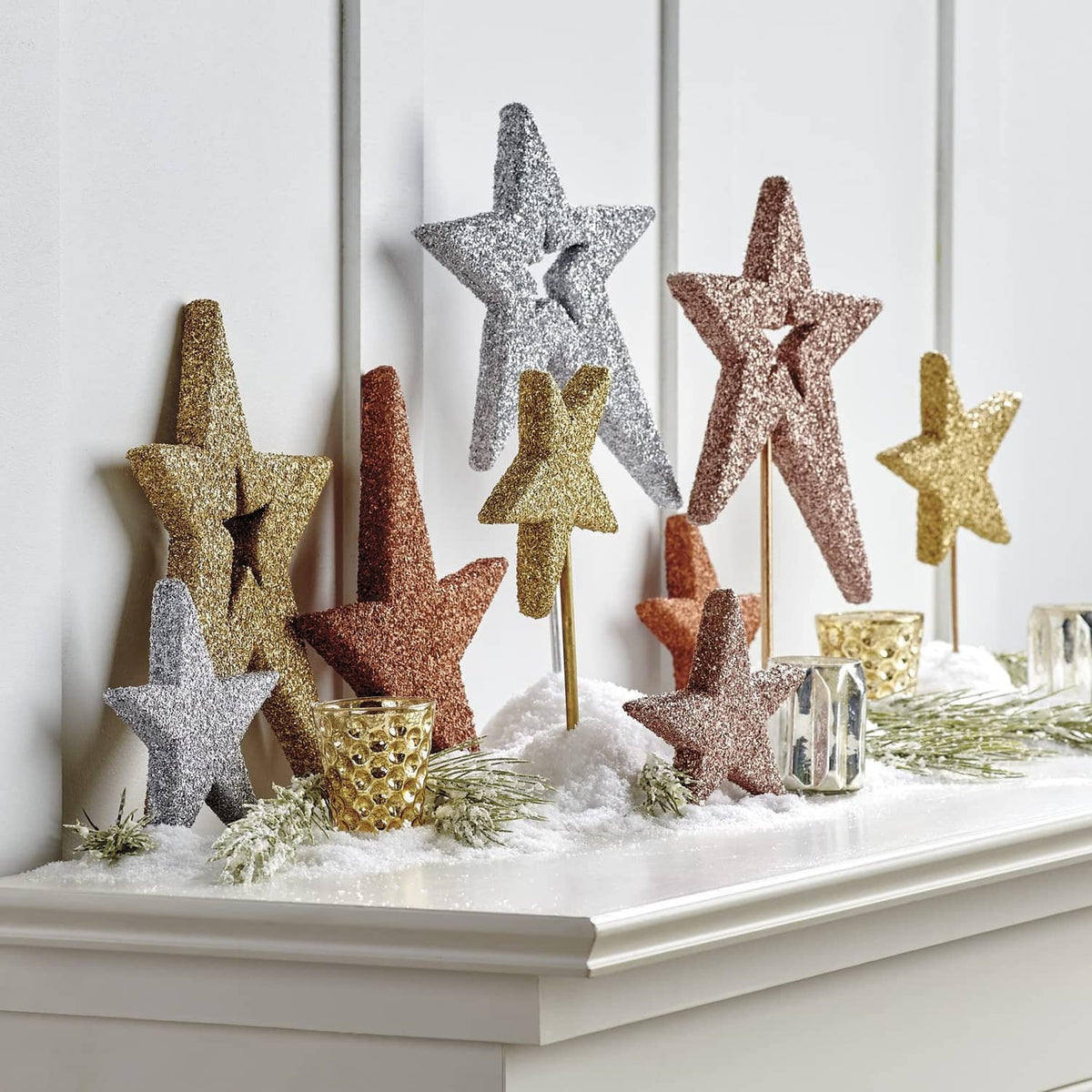 Sparkly star decorations on sticks coated in white, gold, and bronze glitter