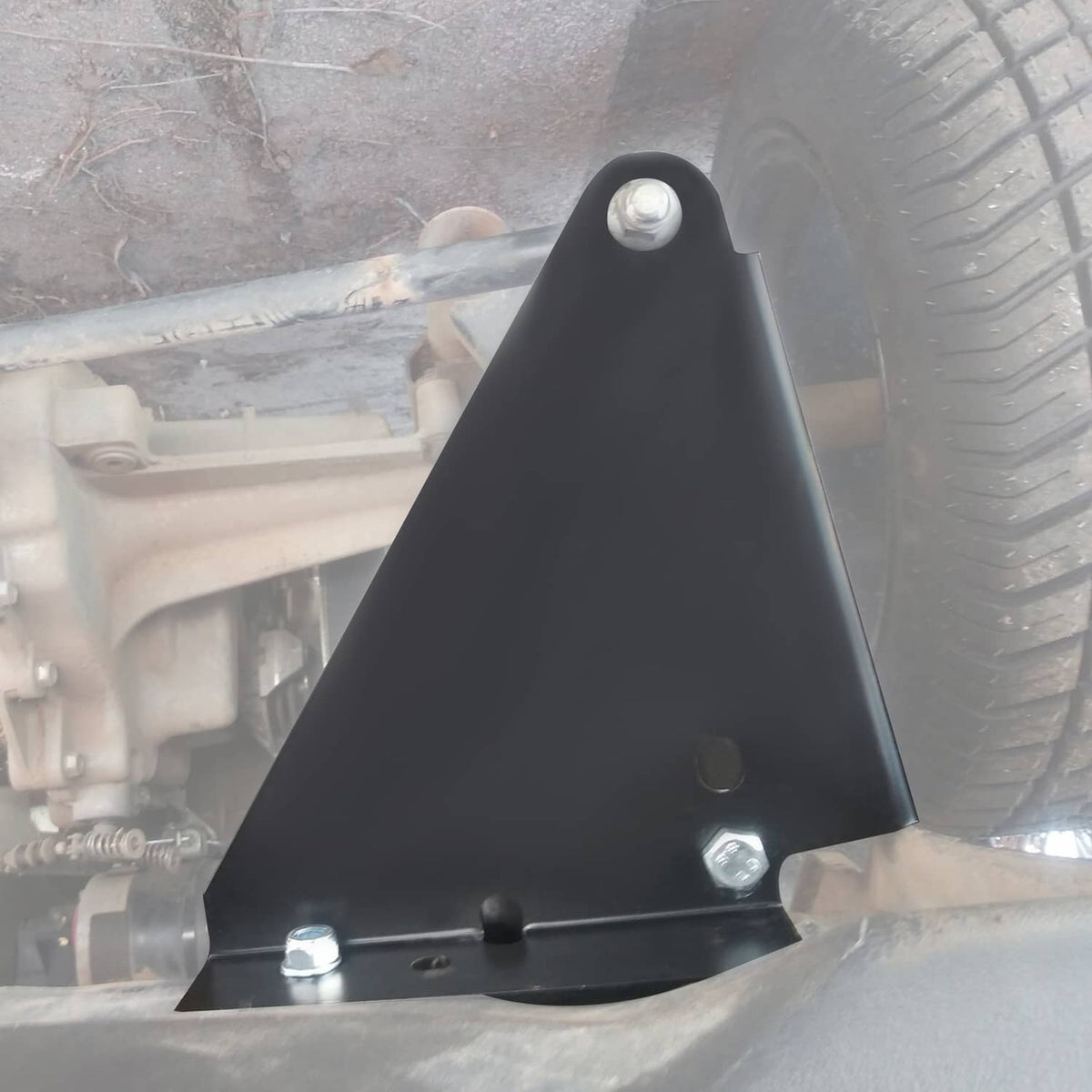 Black lift mounting plate secured with hex bolts beside front suspension components