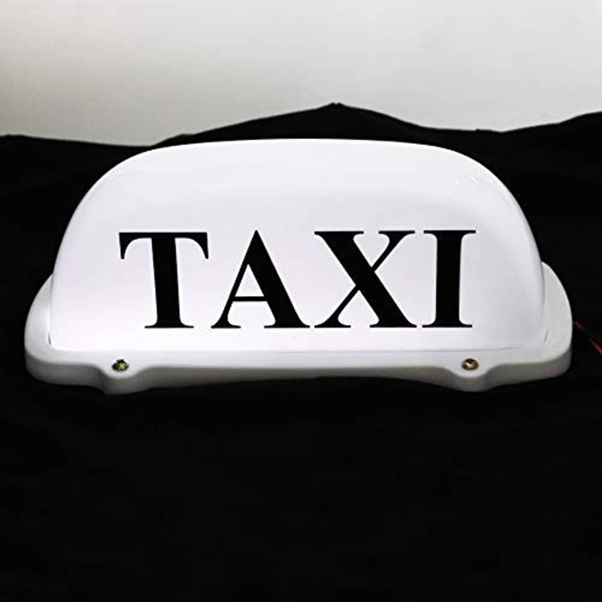 White illuminated "TAXI" roof light topper with red wires visible