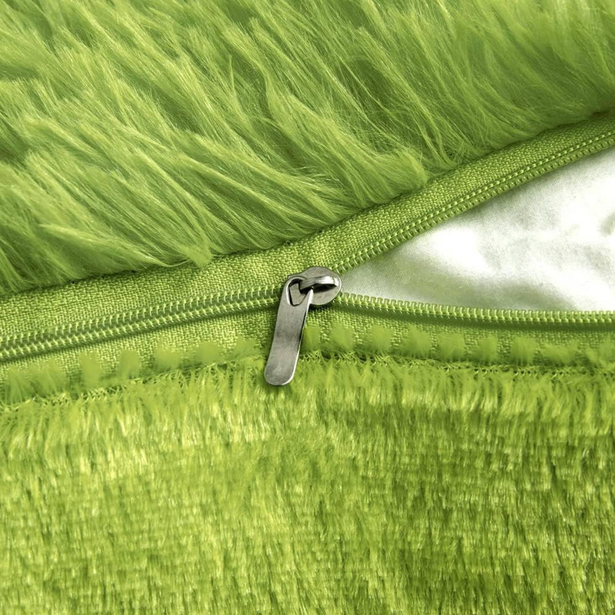 Green faux fur pillow cover with visible zipper and metal pull