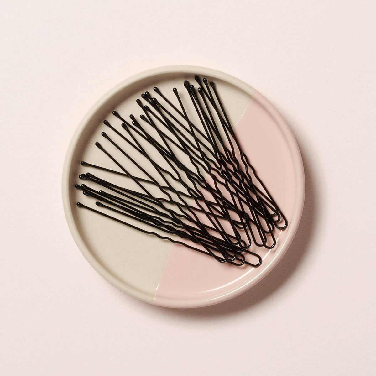 Coiled black hair pins in a round dish, 3-inch extra large U-shaped design