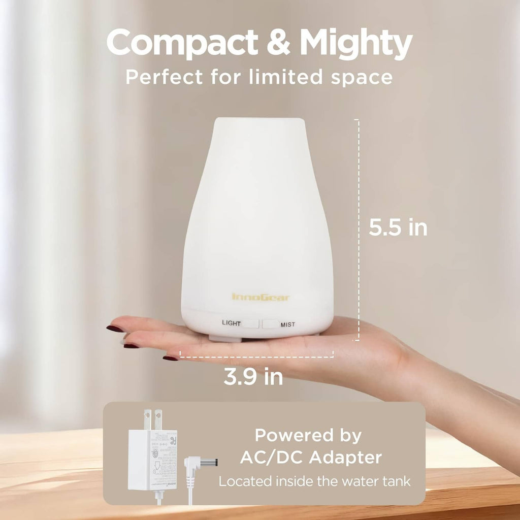 White essential oil diffuser with compact size design, held in a hand