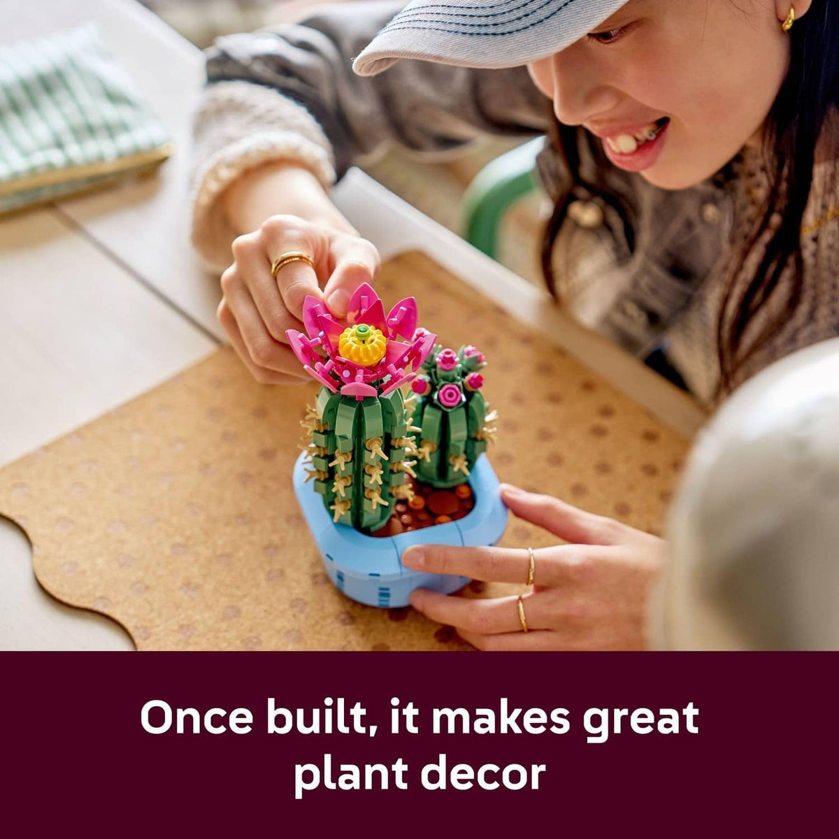 LEGO Botanicals cactus building set placed on table, child holding the blue base