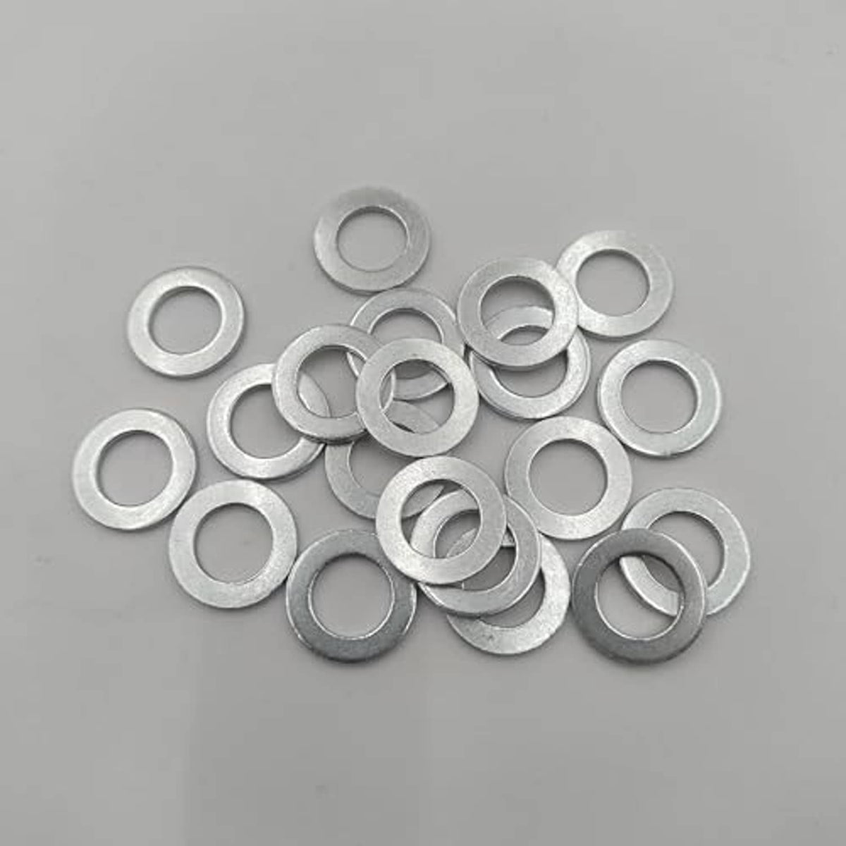 Silver crush washers, loose spread pile, circular rings with central openings