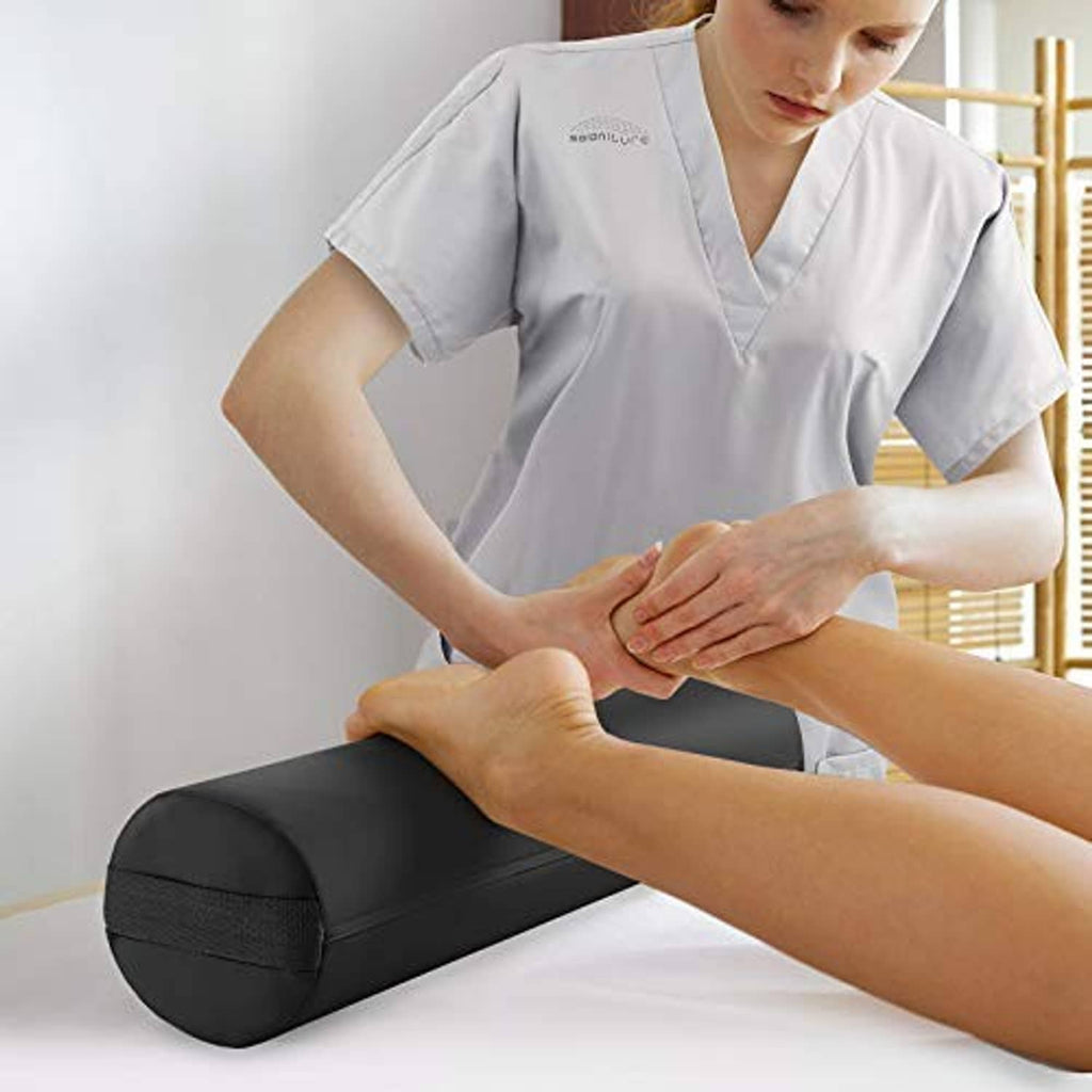 Black cylindrical bolster pillow pad supporting a massage position on a table