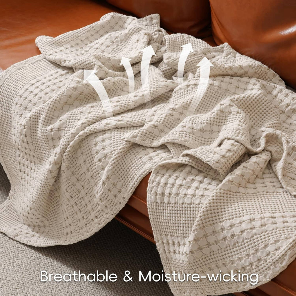 Ivory waffle-weave cotton blanket with textured surface, folded on a couch or bed