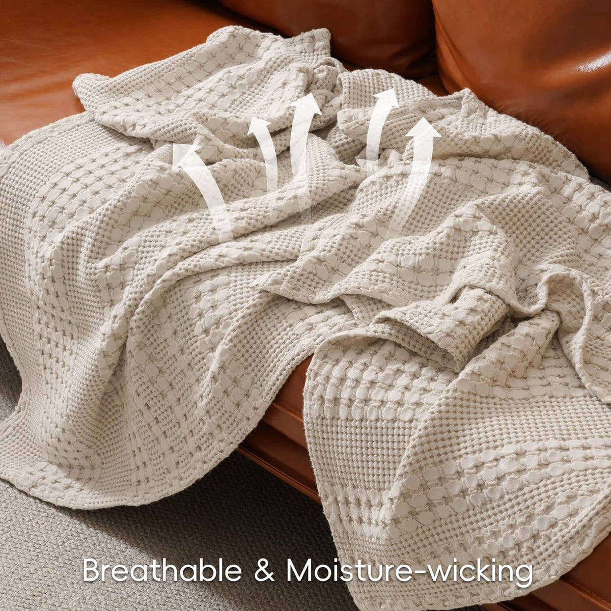 Ivory waffle-weave cotton blanket with textured surface, folded on a couch or bed