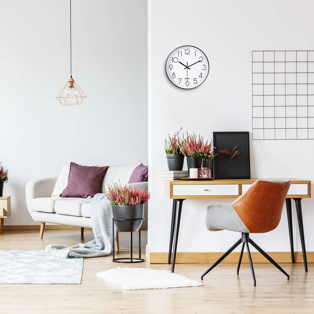 Wall clock with white dial and black rim hanging in a modern room