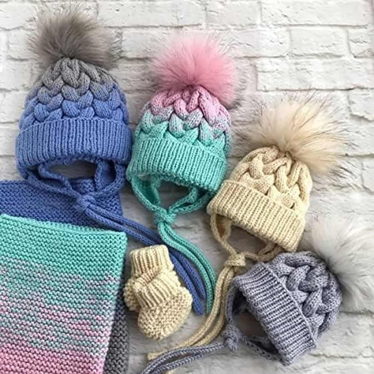 Knitted beanies with pom-poms in blue, pink, mint, cream, and gray with scarf pieces