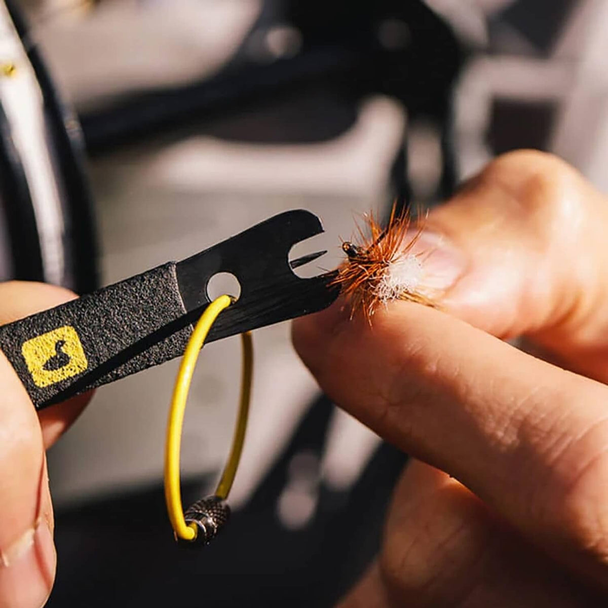 Wire-cutting nippers with yellow cord; sparks near the cutting edge
