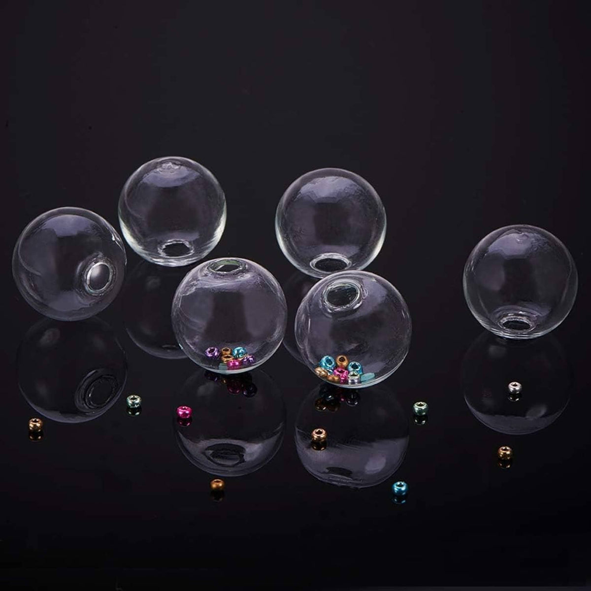 Clear glass globe bottles with metal caps, some containing colorful confetti-like pieces