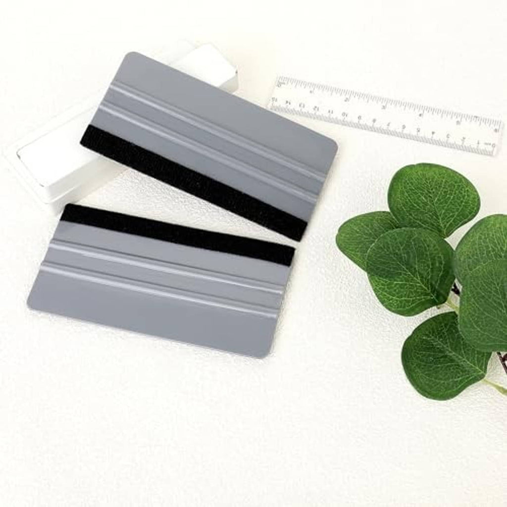 Two felt squeegees with ribbed gray pads and black foam handles, square shape