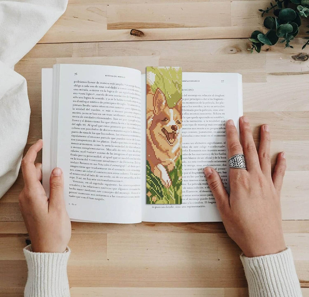 Green animal cross-stitch bookmark strip placed between book pages