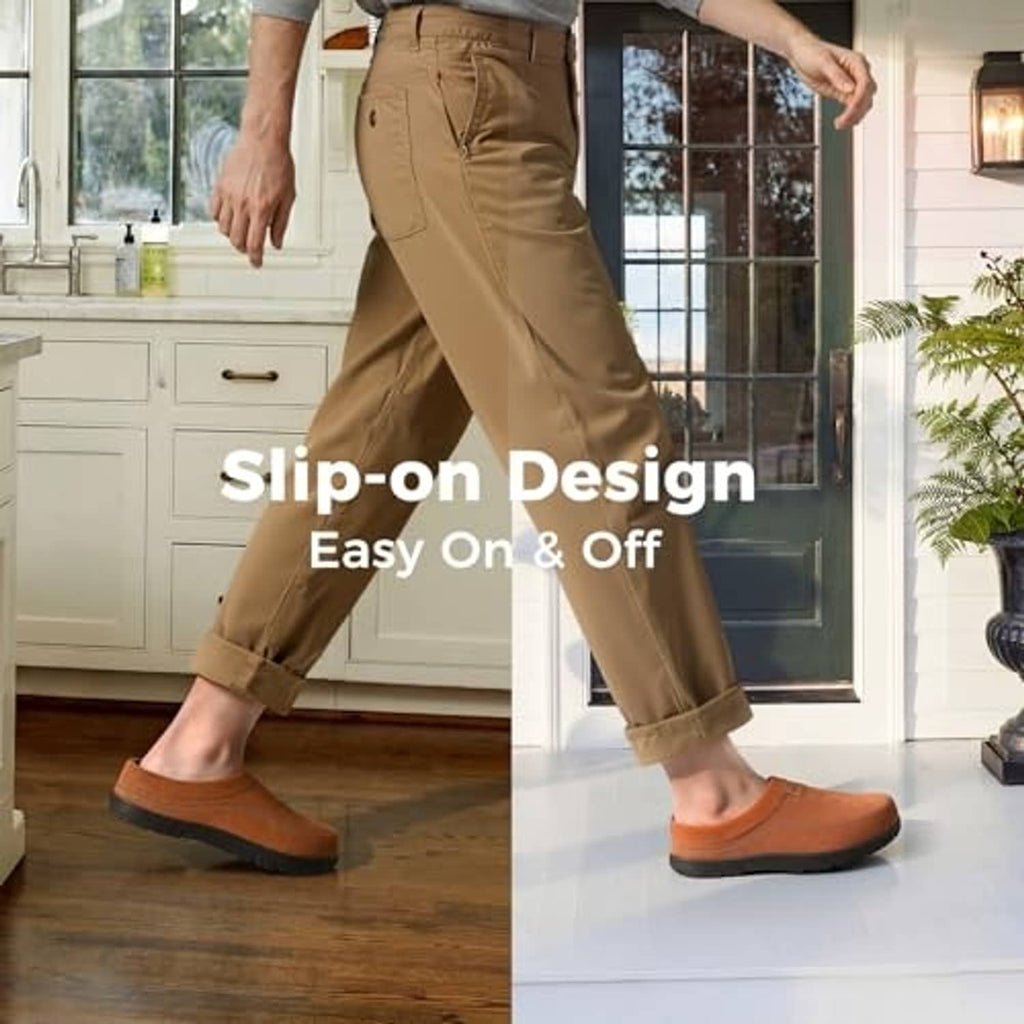 Tan men's slip-on moccasin house shoes worn on wooden floor