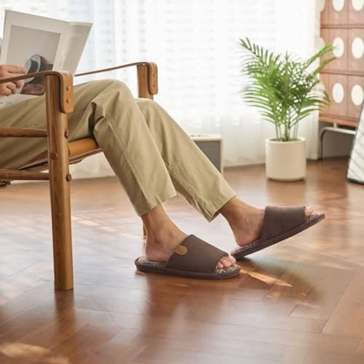 Brown plaid-lined slip-on slippers on a person standing indoors