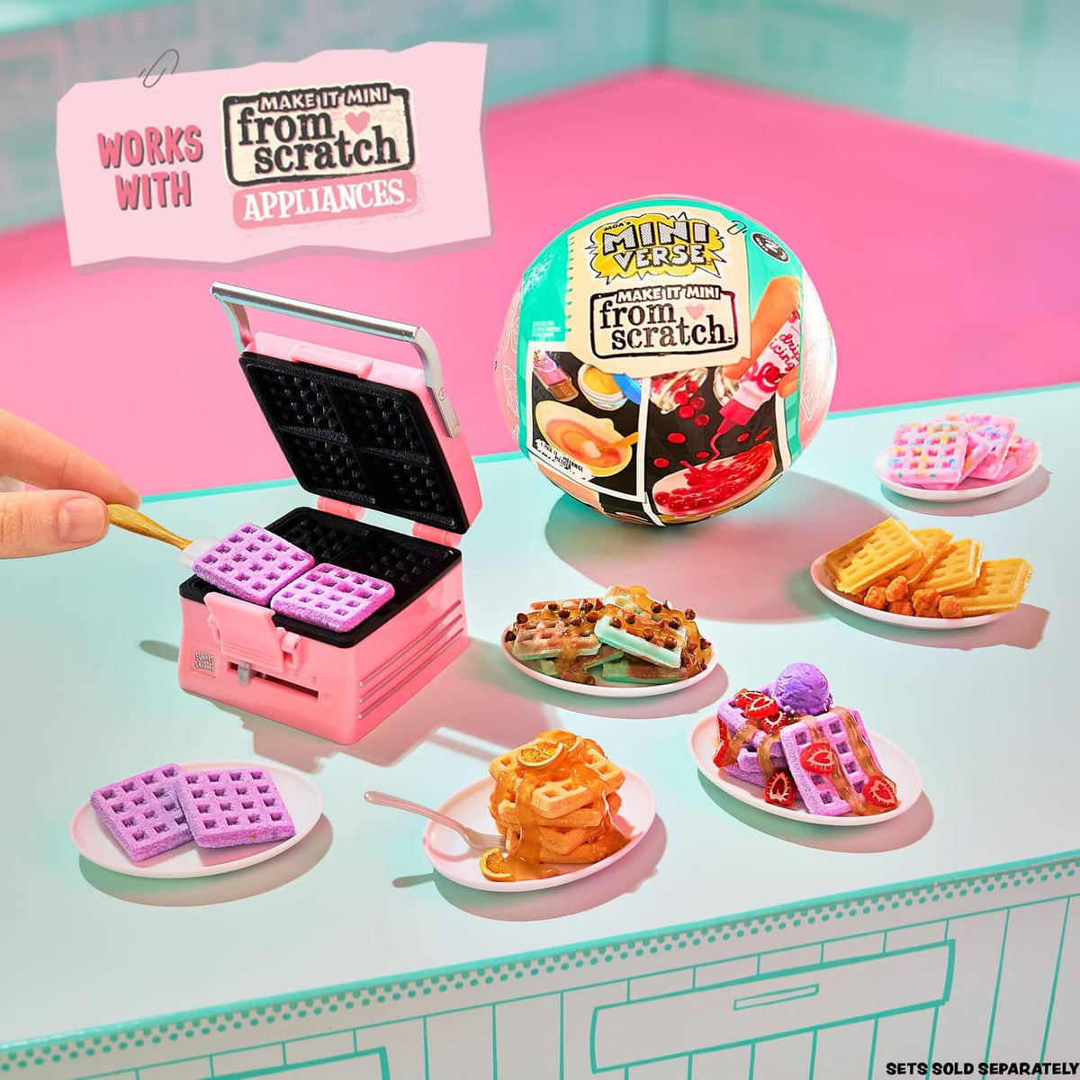 Mini kitchen appliance playset with open waffle iron and small food dishes on counter